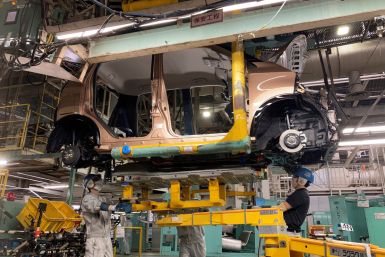 Workers install a battery for a new electric vehicle model at Mitsubishi Motor Corp's factory in Kurashiki